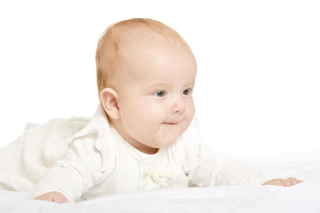 Adorabile bambina su una coperta su uno sfondo bianco