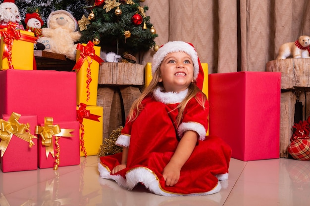 Adorabile bambina vestita con abiti natalizi.