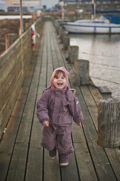 Adorabile bambino che cammina sul molo la sera in Danimarca