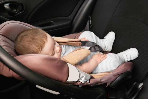 Adorabile bambino che dorme nel seggiolino per bambini all'interno dell'auto