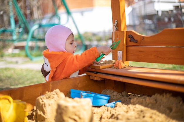 Adorabile bambino che gioca nella sandbox bambino carino in pigiama volpe gioca nella sabbia ritratto di a