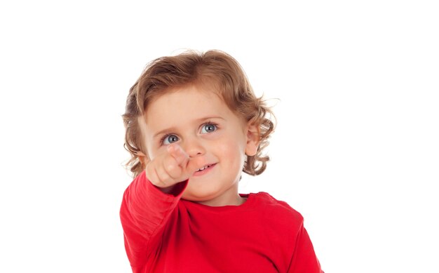 Adorabile bambino con la camicia rossa che punta con il dito