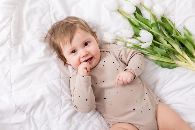 adorabile bambino con tulipani bianchi su uno spazio banner coperto per il testo