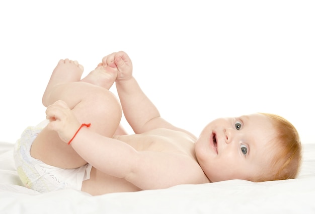 Adorabile bambino in coccole su una coperta su uno sfondo bianco