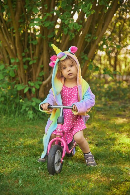 Adorabile bambino in sella a una bicicletta in giardino