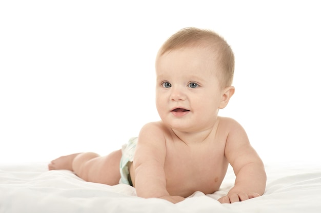 Adorabile bambino sdraiato in coccole su una coperta su uno sfondo bianco