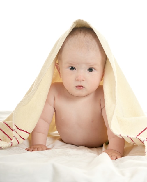 Adorabile bambino sdraiato su una coperta su uno sfondo bianco