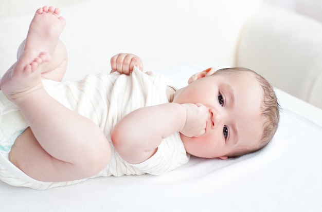 Adorabile bambino sdraiato sulla schiena nel soggiorno