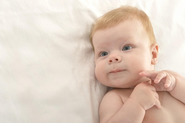 Adorabile bambino sulla coperta su uno sfondo bianco