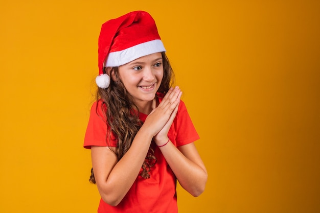 Adorabile bambino vestito da mamma claus che prega