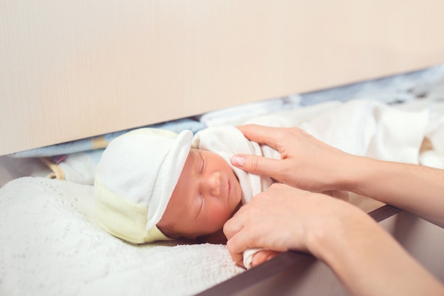 Adorabile neonato che dorme nello scaffale nel comò