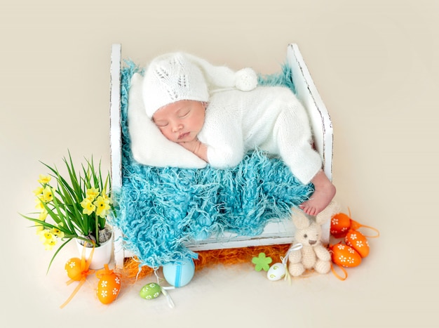 Adorabile neonato che dorme sul letto minuscolo