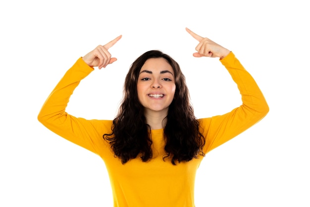 Adorabile ragazza adolescente con maglione giallo isolato su un muro bianco