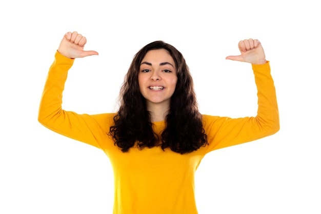 Adorabile ragazza adolescente con maglione giallo isolato su un muro bianco