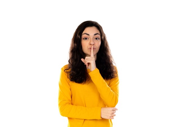 Adorabile ragazza adolescente con maglione giallo isolato su un muro bianco