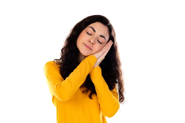 Adorabile ragazza adolescente con maglione giallo isolato su un muro bianco