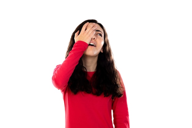 Adorabile ragazza adolescente con maglione rosso isolato su un muro bianco