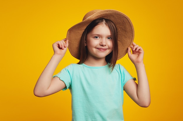 Adorabile ragazza attiva positiva che indossa una maglietta blu e un cappello elegante