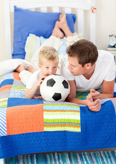 Adorabile ragazzino e suo padre a guardare una partita di calcio