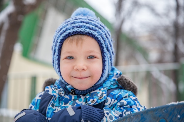 Adorabile ragazzino in un parco d'inverno