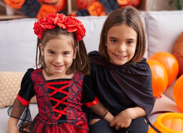 Adorabile ragazzo e ragazza che indossano il costume di Halloween che si abbracciano a casa