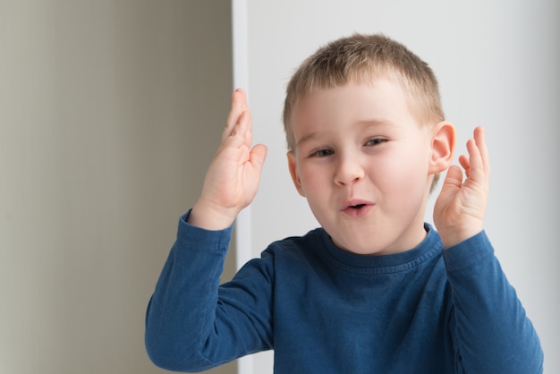 Adorabile ragazzo emotivo con le mani sollevate