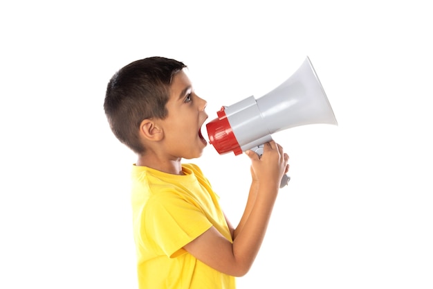 Adorabile ragazzo latino che indossa una maglietta gialla con un parlare con un megafono isolato su uno sfondo bianco