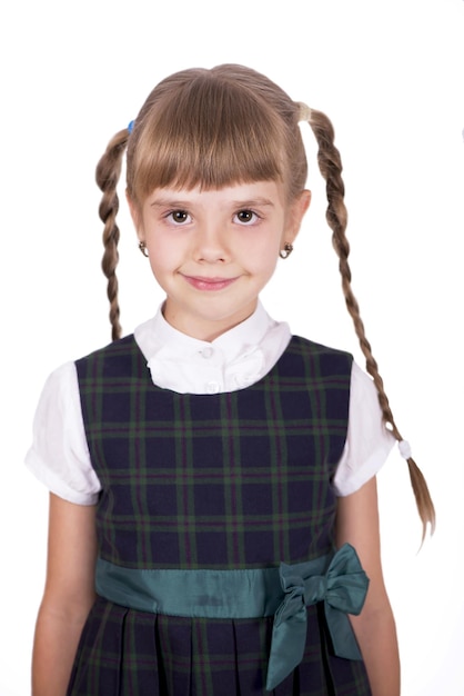 Adorabile scolaretta con un sorriso felice che tiene le braccia incrociate Piccola scolaretta che sembra carina in uniforme scolastica Scolaretta carina con lunghi capelli castani e aspetto affascinante