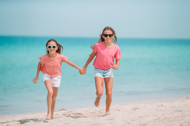 Adorabili bambine divertirsi sulla spiaggia