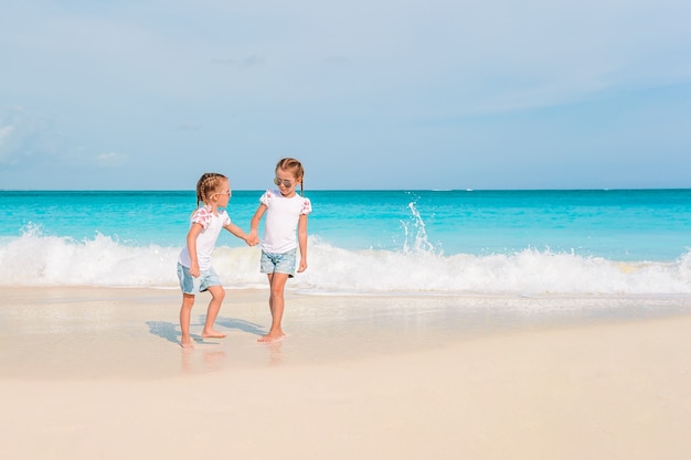 Adorabili bambine si divertono molto in spiaggia.