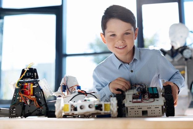 Adorabili bambini pre-adolescenti che ispezionano l'officina del veicolo robotico