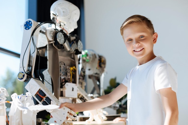 Adorabili bambini pre-adolescenti che ispezionano l'officina del veicolo robotico