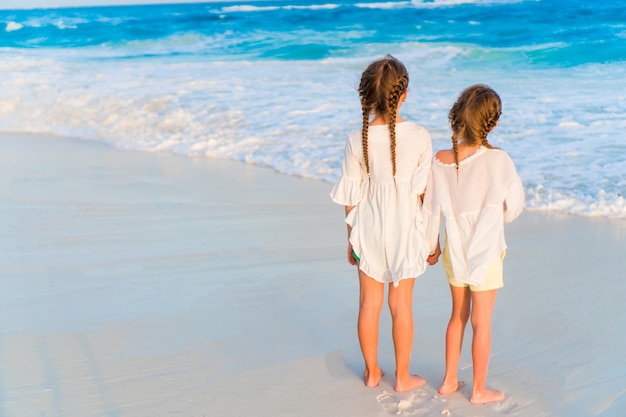 Adorabili sorelline insieme sulla spiaggia