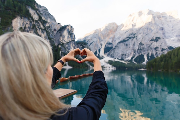 Adoro viaggiare e avventura. La viandante della donna mostra il segno del cuore