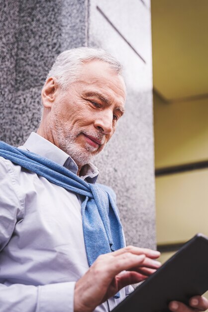 Adulto maturo utilizzando il suo tablet all'aperto