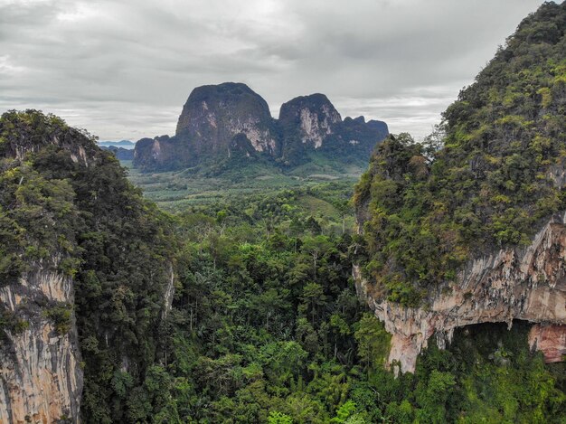 AEREA: Veduta aerea mozzafiato delle alte montagne ricoperte dalla foresta tropicale che domina la valle vuota nel cuore dell'isola esotica.