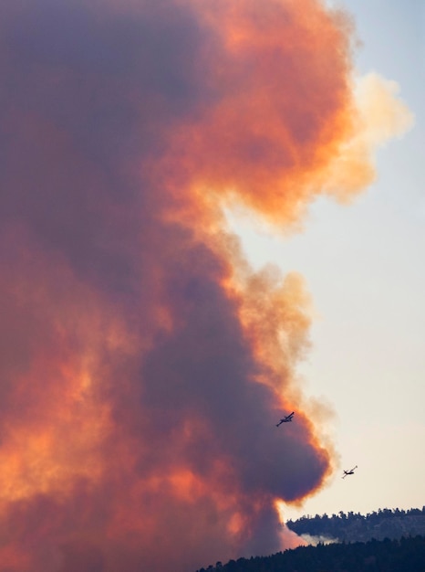 Aerei antincendio sullo sfondo del fumo del fuoco e del fuoco sull'isola greca di Evia Grecia