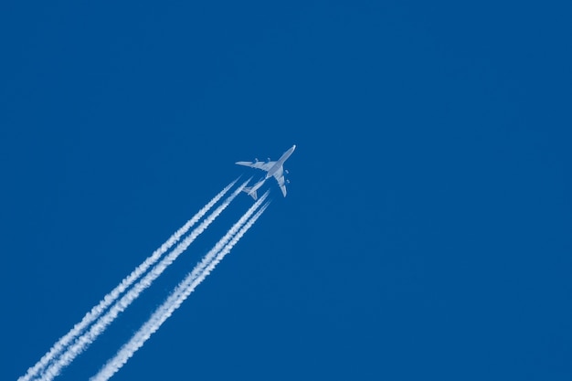 aereo a reazione con un pennacchio bianco su un cielo blu