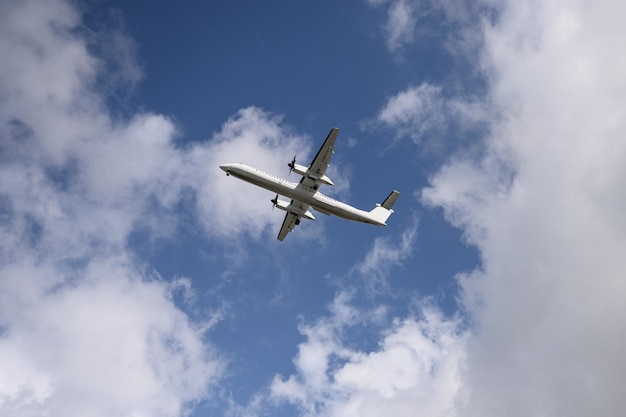 Aereo ad elica nazionale che vola nel cielo blu con nuvoloso