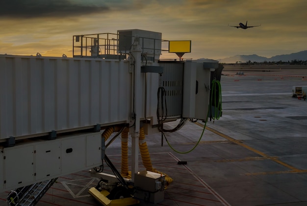 Aereo che decolla nel tramonto rosso nel ponte di imbarco utilizzato per collegare l'aeroporto sull'aeroporto di Sky Harbor con Phoenix, Arizona, Stati Uniti