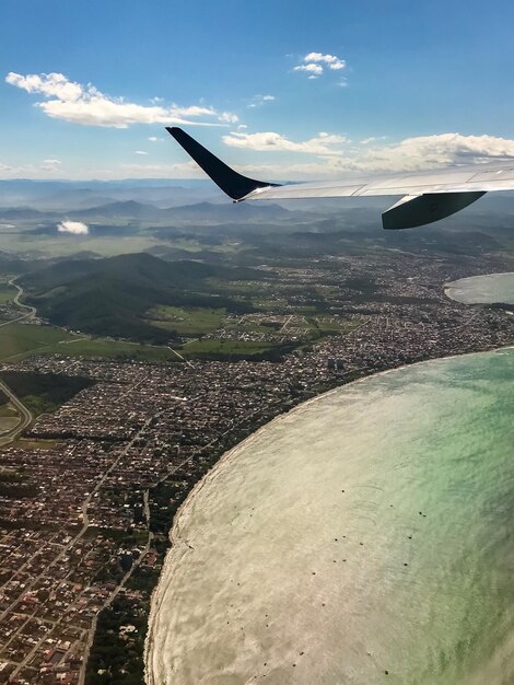 Aereo che vola sopra il paesaggio contro il cielo