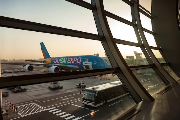 Aereo con testo DUBAI EXPO sullo sfondo dell'aeroporto internazionale del terminal della finestra