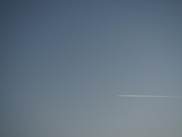 Aereo e sentiero nel cielo blu della sera Sfondo astratto su uno spazio o un tema aerodinamico Sfumatura di colore