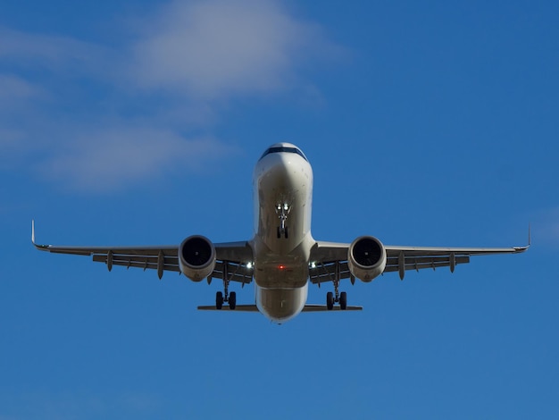 Aereo passeggeri bianco che vola nel cielo nuvole sullo sfondo