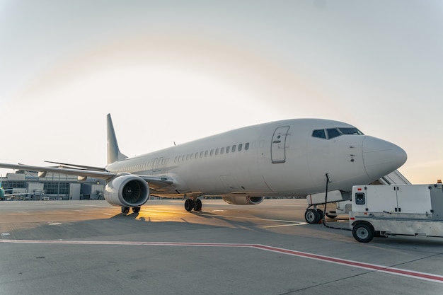 Aereo passeggeri moderno all'aeroporto al tramonto