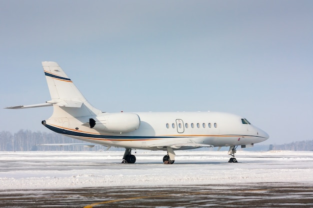 Aereo privato bianco in un freddo aeroporto invernale