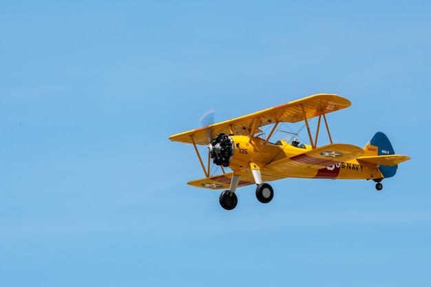 Aereo vintage in volo contro un cielo blu durante uno spettacolo aereo