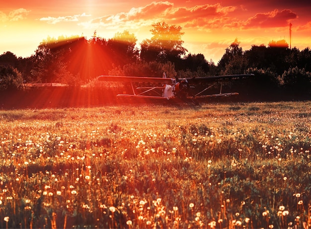 Aereo vintage sul campo al tramonto con sfondo di raggi di luce drammatici hd