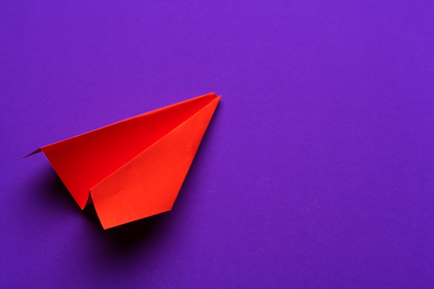 aeroplano di carta bianco su un viola