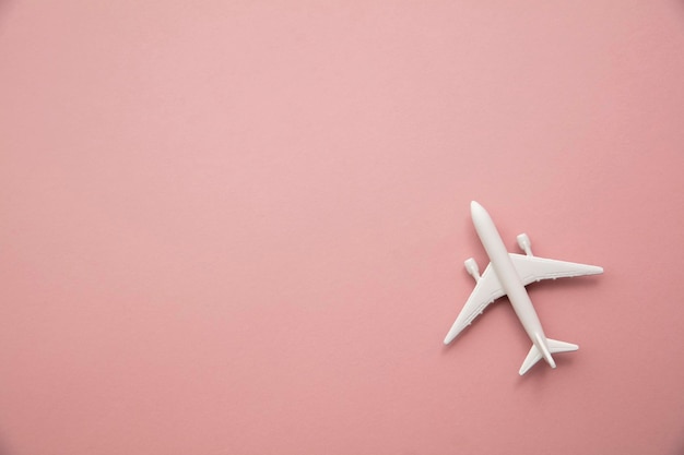 aeroplano giocattolo bianco su sfondo rosa pastello. Sfondo di viaggio di volo con spazio per la copia.